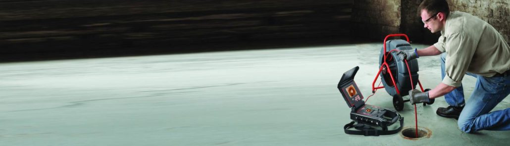 commercial main line repair man with snake machine clearing the main drain.