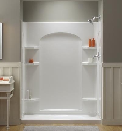Modern white shower with built-in shelves and glass door.