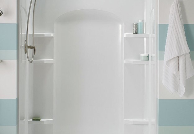 Modern white shower enclosure with sliding doors in a light bathroom.